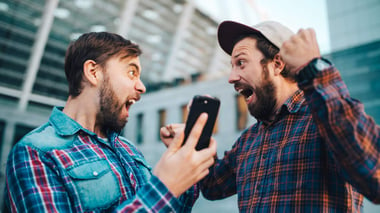 two men celebrating with smart phones